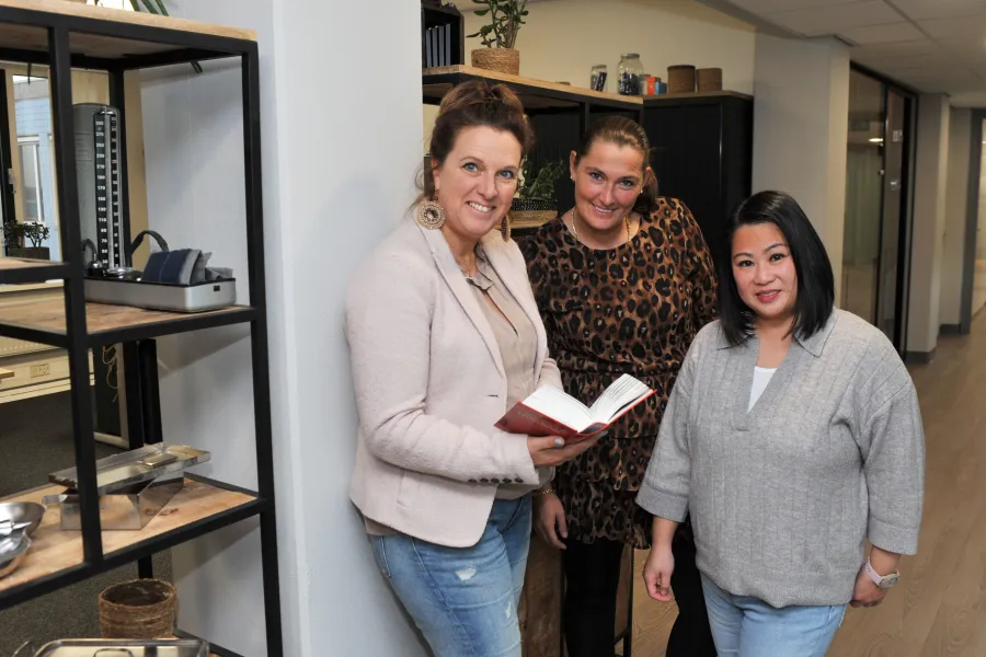 3 collega's die ADL-training volgen kijken naar camera